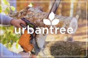Close-up of hands operating a chainsaw to cut a log, with the "urbantree" logo overlaid.
